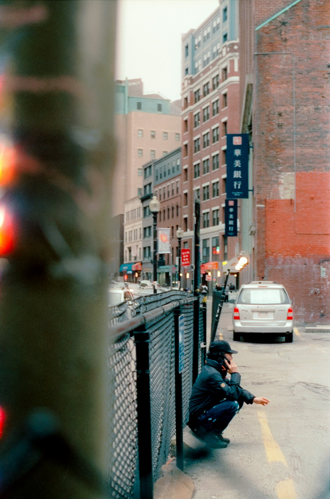 Photographer crouching to photograph a street scene